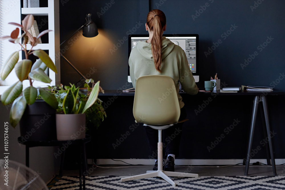 Leinwandbilder red-haired woman working remotely in stylish home office setup, focusing on computer screen displayi