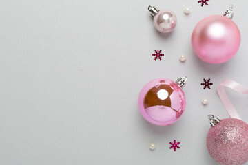 Pink christmas balls with decor on color background, top view