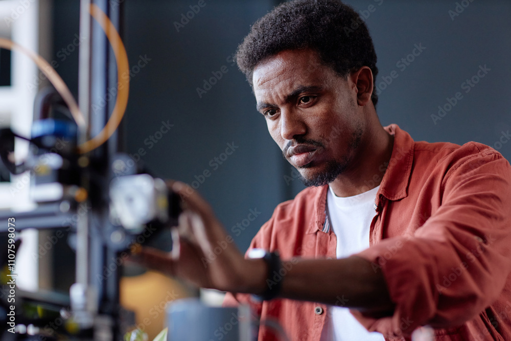 Poster black person concentrating on operating 3d printer in a workshop, adjusting settings for precise out