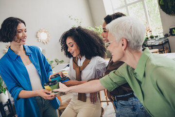 Photo of four diverse women businessladies feminists share drink coffee cafe relax have fun office loft room interior indoors workspace