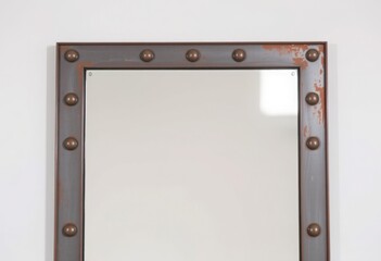 Square mirror with a weathered iron frame and exposed rivets for