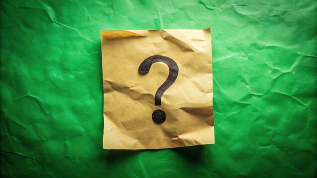 A simple question mark drawn in black ink on a piece of crumpled brown paper against a green background.
