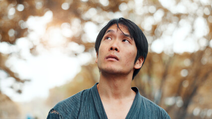 Man, thinking and reflection in nature for idea, peace and mindset for martial arts practice in Tokyo. Japanese samurai, daydreaming and relax in park with nostalgia, memories and decision for sport