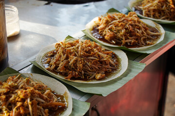 Close-up view of several plates of Char Kway Teow, a popular Malaysian street food, served on...