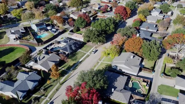 Upscale suburban houses with swimming pools, large fenced backyard, colorful fall foliage autumn leaves in Coppell suburbs Dallas Fort Worth metroplex, fast growing housing market estate, flyover
