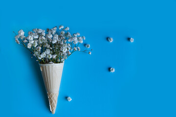 bouquet of red roses with white gypsophila in waffle ice cream vase
