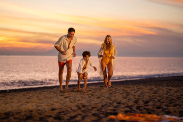 A happy family enjoying their holiday at sunset, laughing and having fun together by the beach.