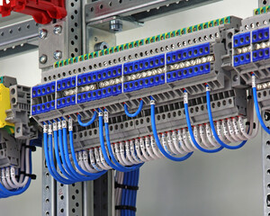 Electrical screw through terminals with connected insulated wires in an electrical switchboard.