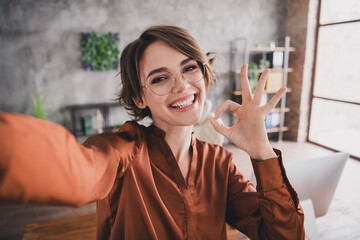 Photo of pretty young girl take selfie photo show okey approve wear brown silk shirt coworking...