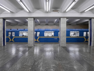 Train at the subway station in motion, side view, empty station. Poshtova ploscha, Kyiv, Ukraine.