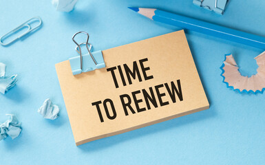 Time to Renew text on paper on blue background near blue pen