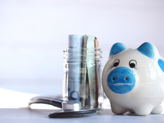 A lot of coins and piggy bank in the concept of saving money and finance.Selection focus.