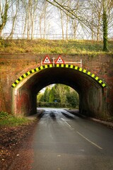 Low railway bridge crossing a country road in autumn