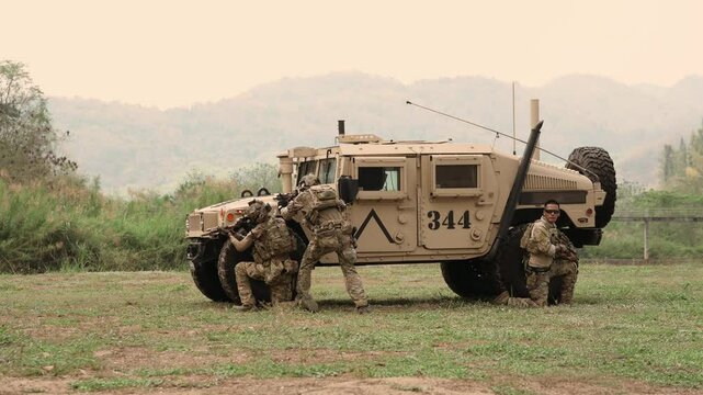 United States Army in camouflage uniforms operation in the forest
with armored vehicle