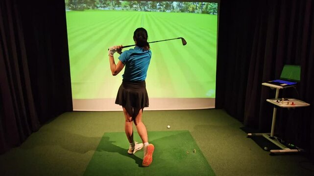Professional female golfer holding club playing golf indoors on golf simulator concept