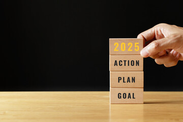 2025 GOAL PLAN ACTION. start up business. new year. Put last piece of wooden cube with the letters...