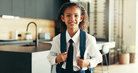 Portrait, happy kid and student with school uniform in home for learning, education or study in kitchen. Face, smile or girl child in elementary for first day, growth or ready for knowledge in Brazil