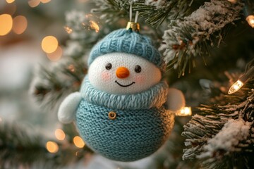 Obraz premium Cute knitted snowman ornament hanging on a christmas tree, creating a warm and festive holiday atmosphere