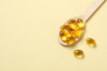 Wooden spoon on a color background. Fish oil tablets. Biologically active additives. Omega 3, 6,...
