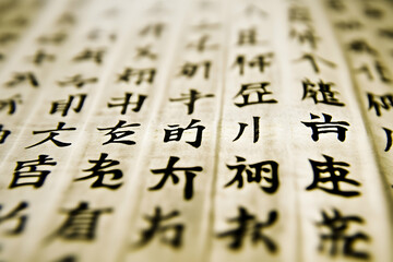 Close-up shot of ancient Chinese script on aged paper, showcasing intricate details and texture.  Ideal for projects on history, literature, or Asian culture.