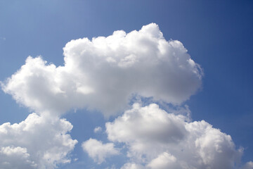 The image shows a clear blue sky with white clouds.