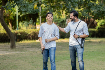 Fototapeta premium A heartwarming moment of a father and son sharing quality time in the park, captured as they walk together after a friendly badminton game