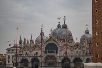 Naklejka premium Vista de la impresionante Basílica de San Marcos en la Plaza de San Marcos, Venecia, con sus icónicas cúpulas y detalles arquitectónicos dorados.
