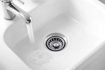 A kitchen sink with water flowing from the faucet, perfect for use in illustrations about home improvement or everyday life