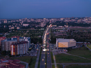 City landscape. Evening view from a drone of the city after sunset. Trees, roads, streets, cars and...