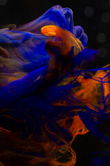 Naklejka premium Abstract background.Mixing blue and orange ink in water.