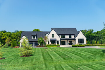 Landscape with large modern country house. Landscape design, mowed lawn and blue sky.