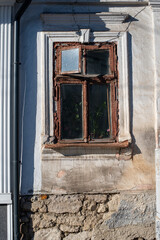 Old vintage wooden window on old house. Dirty wall rough gloomy texture.
