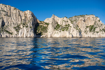 View from the Mediterranean Sea to the rocky coast of the Calanque National Park on a sunny summer day.