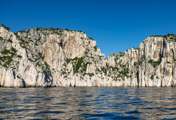 View from the Mediterranean Sea to the rocky coast of the Calanque National Park on a sunny summer day.