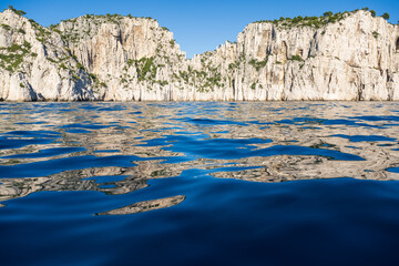 View from the Mediterranean Sea to the rocky coast of the Calanque National Park on a sunny summer day.