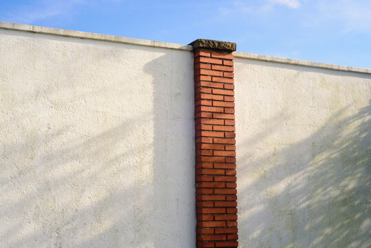 Columna de ladrillo en tapia blanca