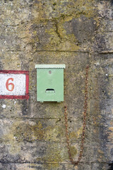 Número 6 pintado junto a buzón en muro de hormigón