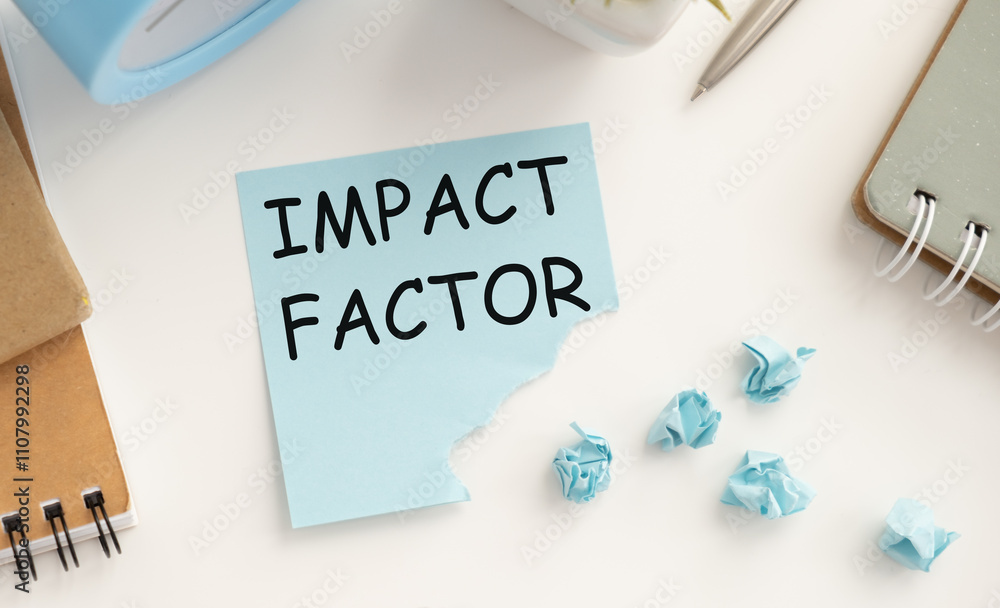 Poster impact factor. text on white paper in a red notepad near different stationery