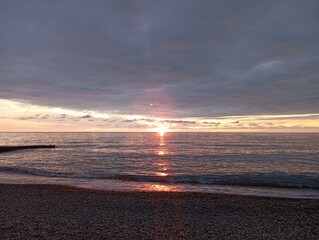 sunset on the beach. Red sunset on the sea. The sun is setting over the sea horizon