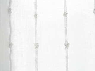 A close-up of a light translucent fabric that plays with the sun's rays, creating a feeling of...