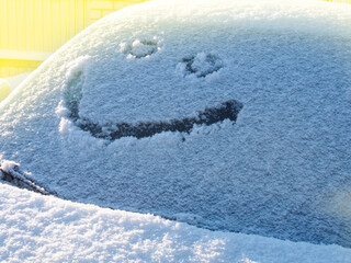 A smile is gently depicted on the snow cover, creating a playful mood and a contrast between cold...