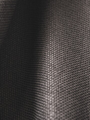 Macro photography of dark fabric, highlighting its texture and depth of color, creating an atmosphere of elegance and comfort