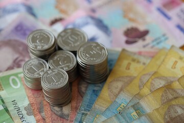 Few stacks of ukrainian money coins lies on old hryvnia banknotes