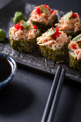 Japanese cuisine. Sushi rolls on a black platter