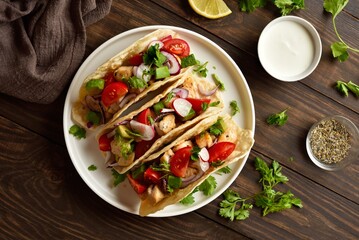 Tacos with vegetables and meat on wooden background