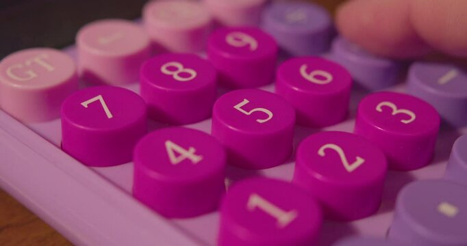 Hand of a businessman making a calculation on a calculator. Calculator buttons and finger close-up. Shallow depth of field.