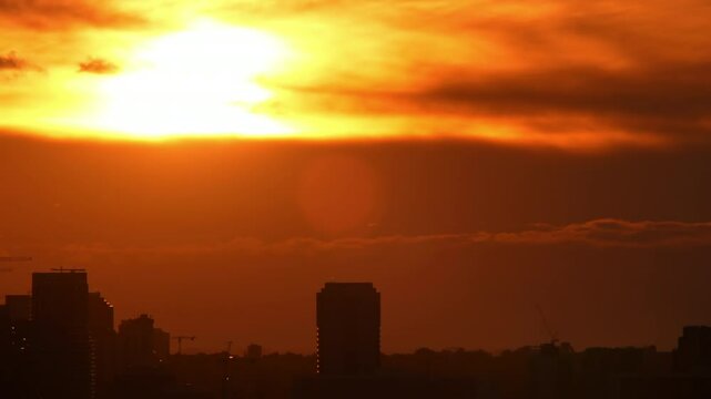 Sunset in the orange yellow red sky timelapse. Epic bloody bright clouds in the evening. Vibrant color background time Lapse. Cinematic rainy summer sky.