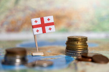 georgian flag with coins on a world map, symbolizing georgia's economy, finance, trade,...