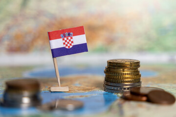 croatia flag with coins on a world map, representing croatia's economy, finance, investments,...