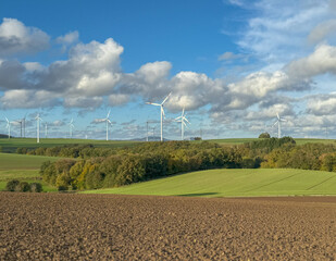 Panoramic view of wind farm or wind park, with high wind turbines for generation electricity with copy space. Green energy concept